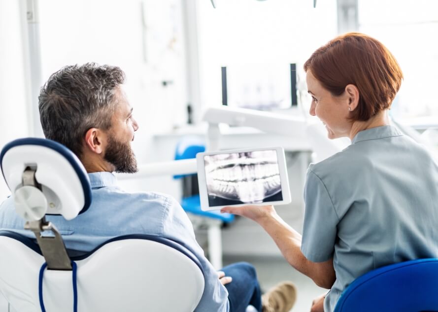 Dentist and dental patient looking at advanced dentistry technology