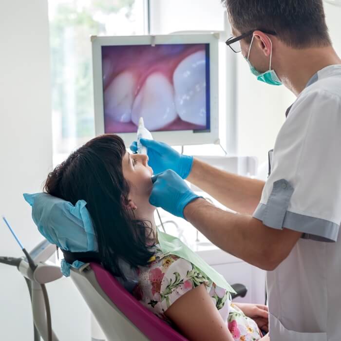 Dentist and dental patient looking at images captured by intraoral camera