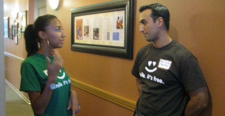 Two dental team members talking at community event