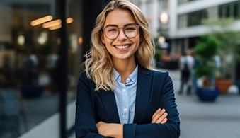 Woman in business attire smiling outside office building