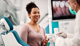 Smiling woman talking to cosmetic dentist about financial options
