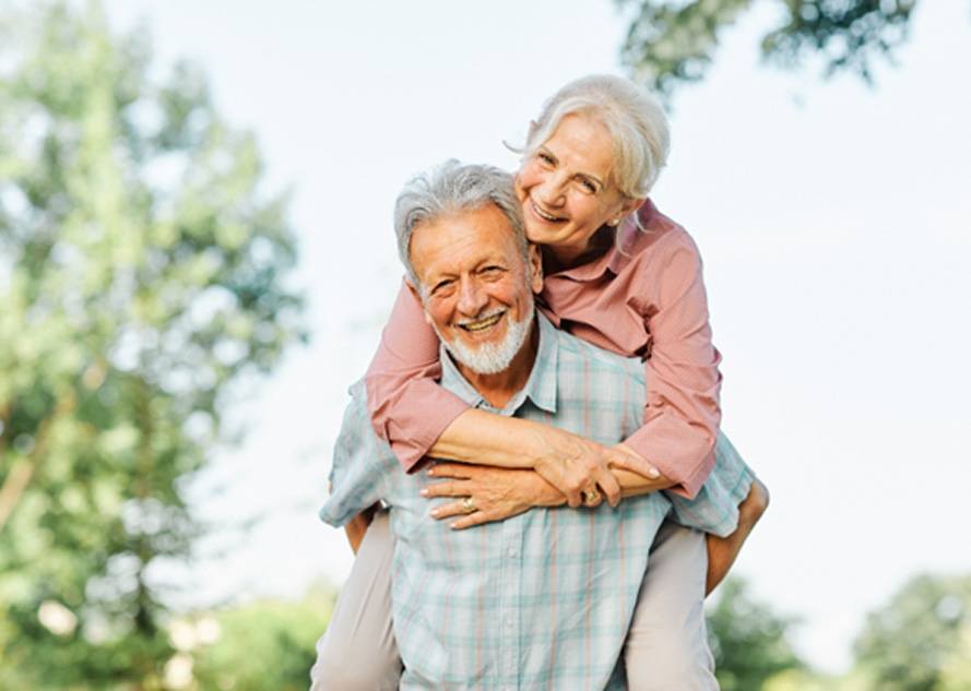 Older couple smiling and enjoying the outdoors