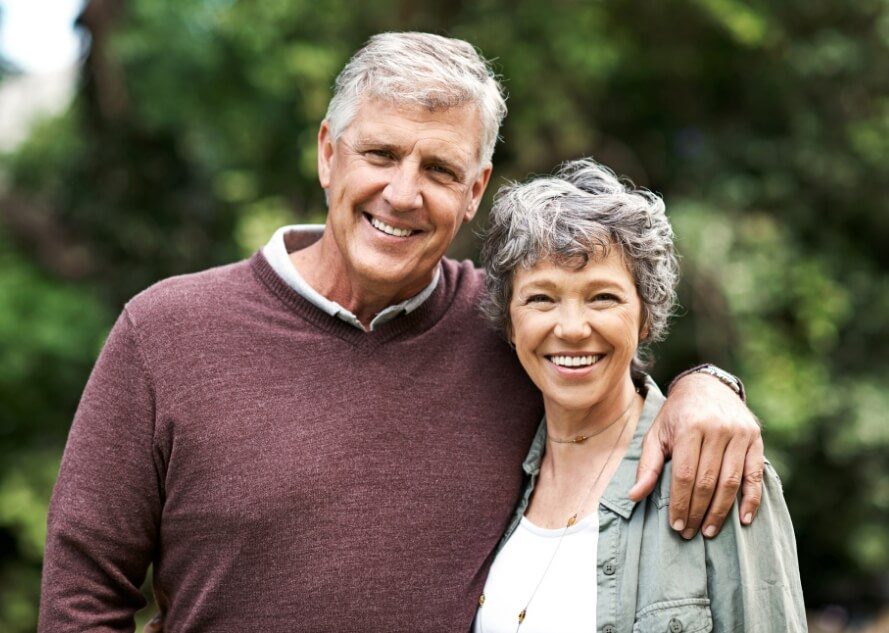 Man and woman with healthy smiles after dental implants