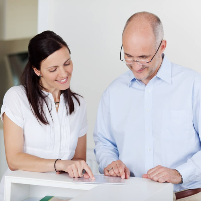 Dentistry team member and dental patient discussing the cost of dental implants