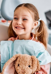 a child smiling and giving her dentist a high-five