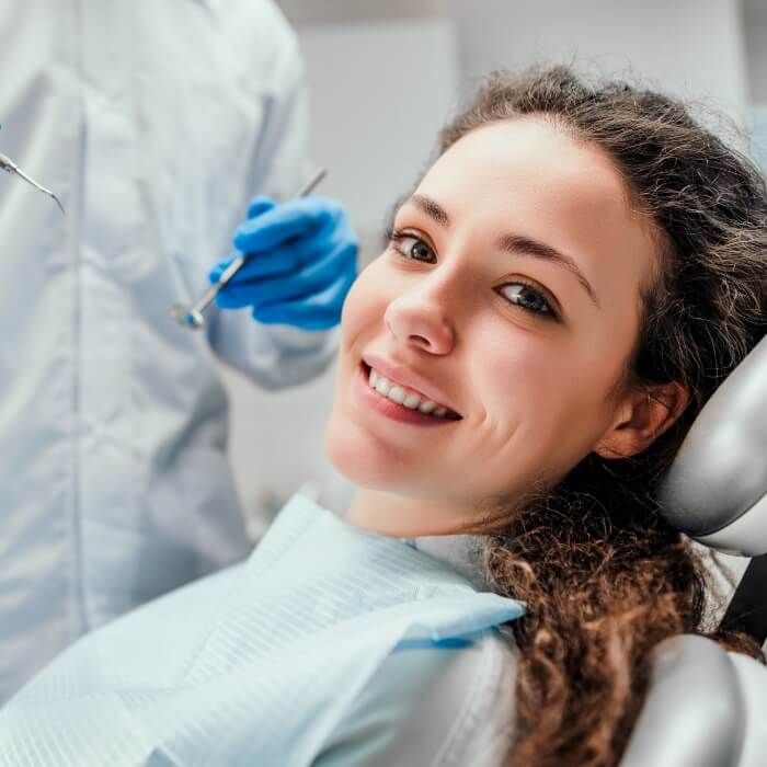 Woman smiling during dental checkup and teeth cleaning visit