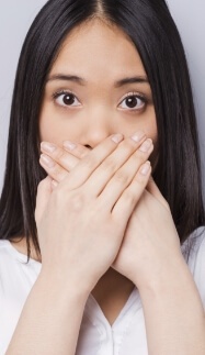 Woman with missing teeth covering her mouth